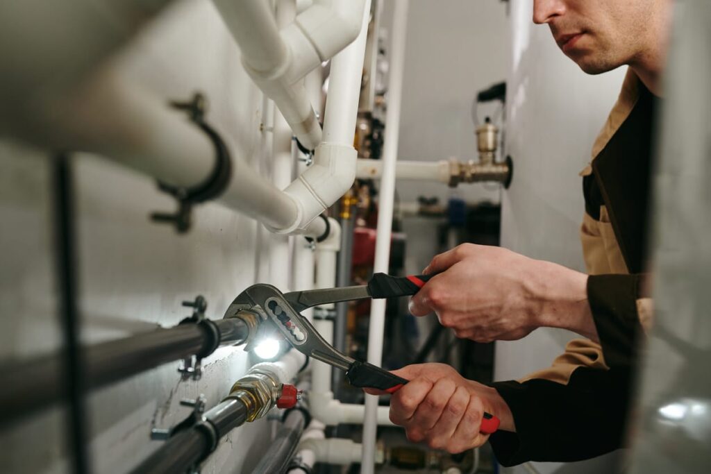 Plumbers maintaining commercial plumbing pipes in Estero