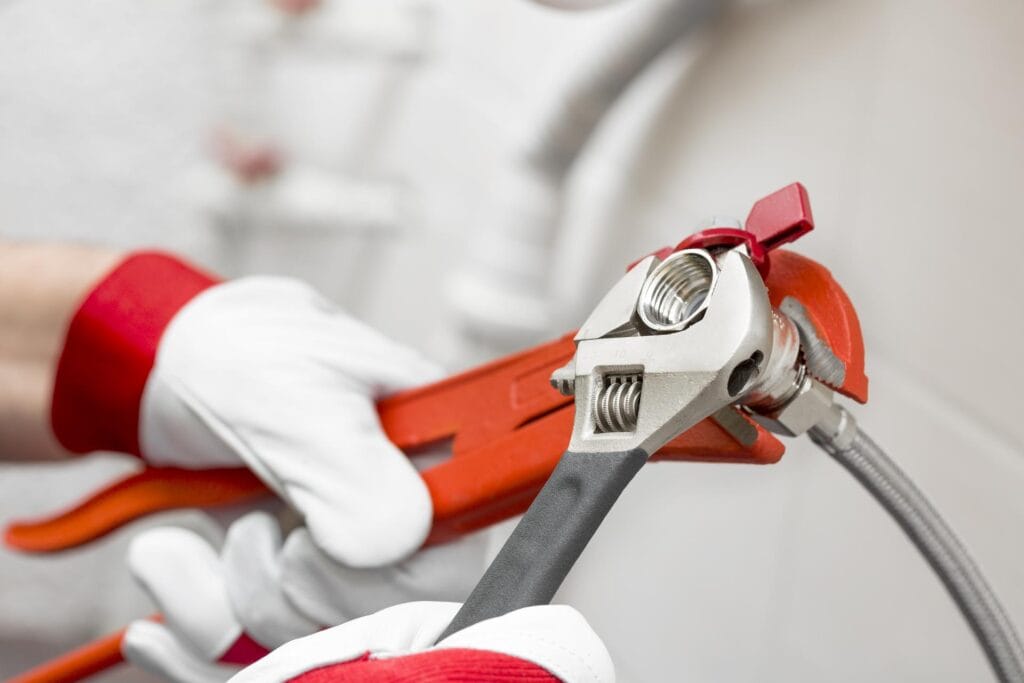 Plumber holding pipe wrenches for an emergency repair in Estero