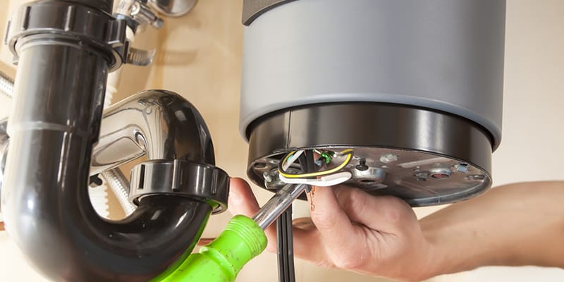 Technician repairing the heating element of a water heater in Estero