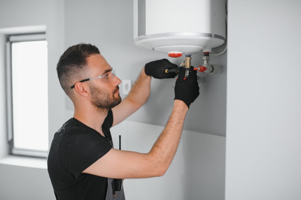 Technician performing water heater maintenance in Estero