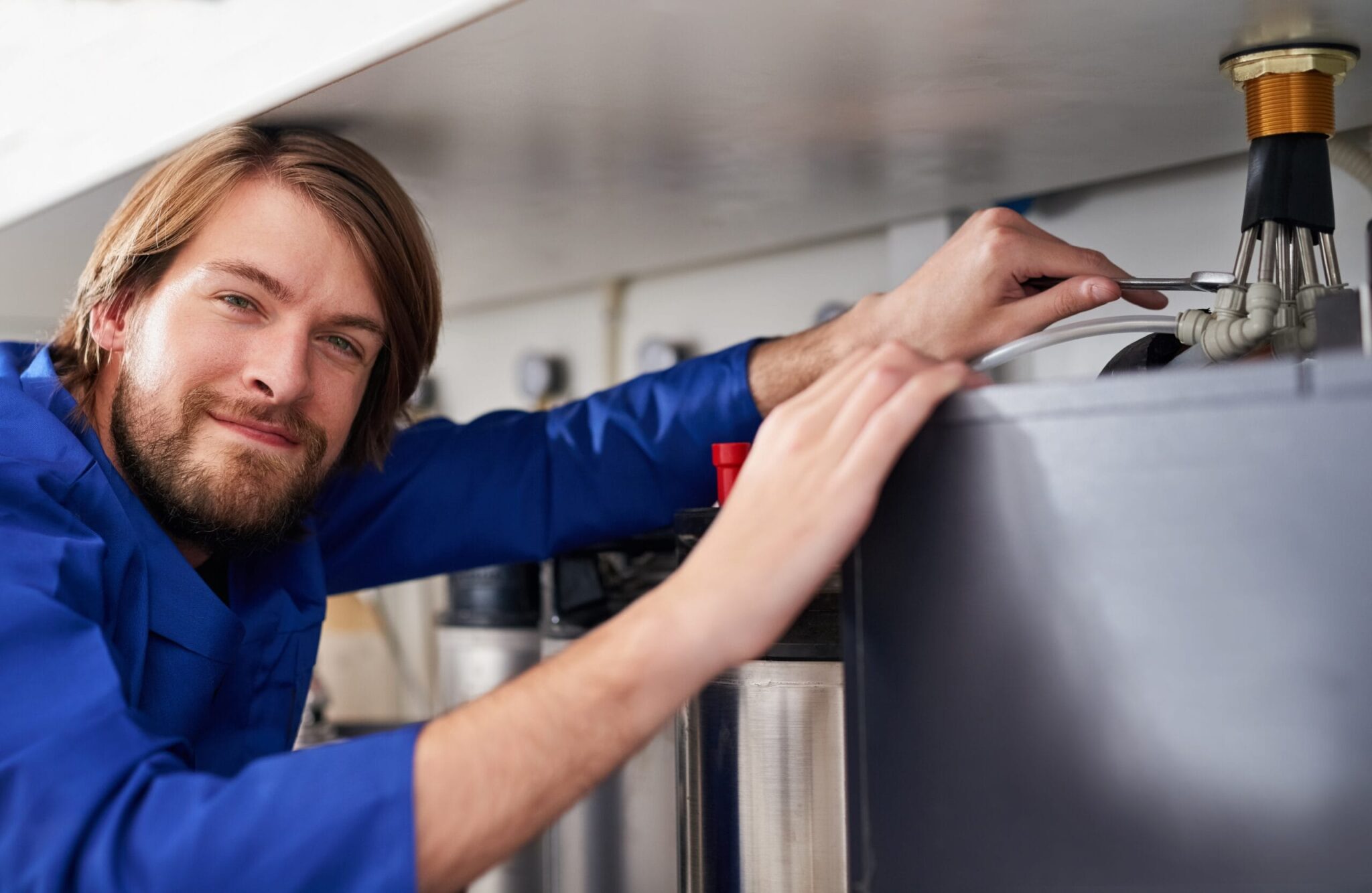 Technician servicing a residential water heater tank in Estero