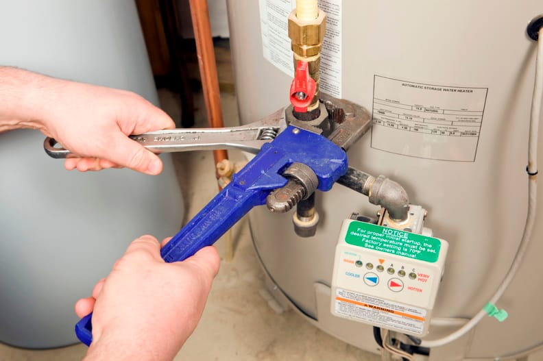 Plumber repairing a water heater valve in Estero